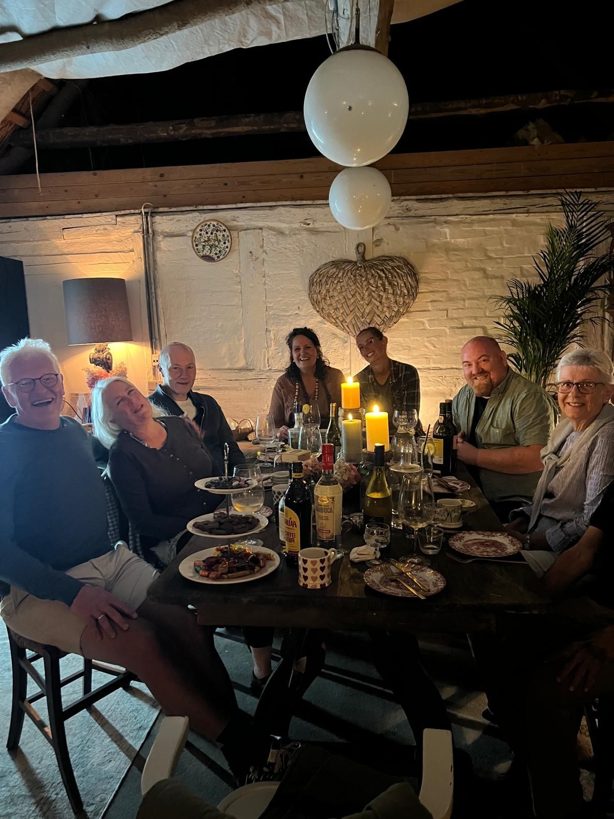 A group of people are sitting around a table with plates of food.
