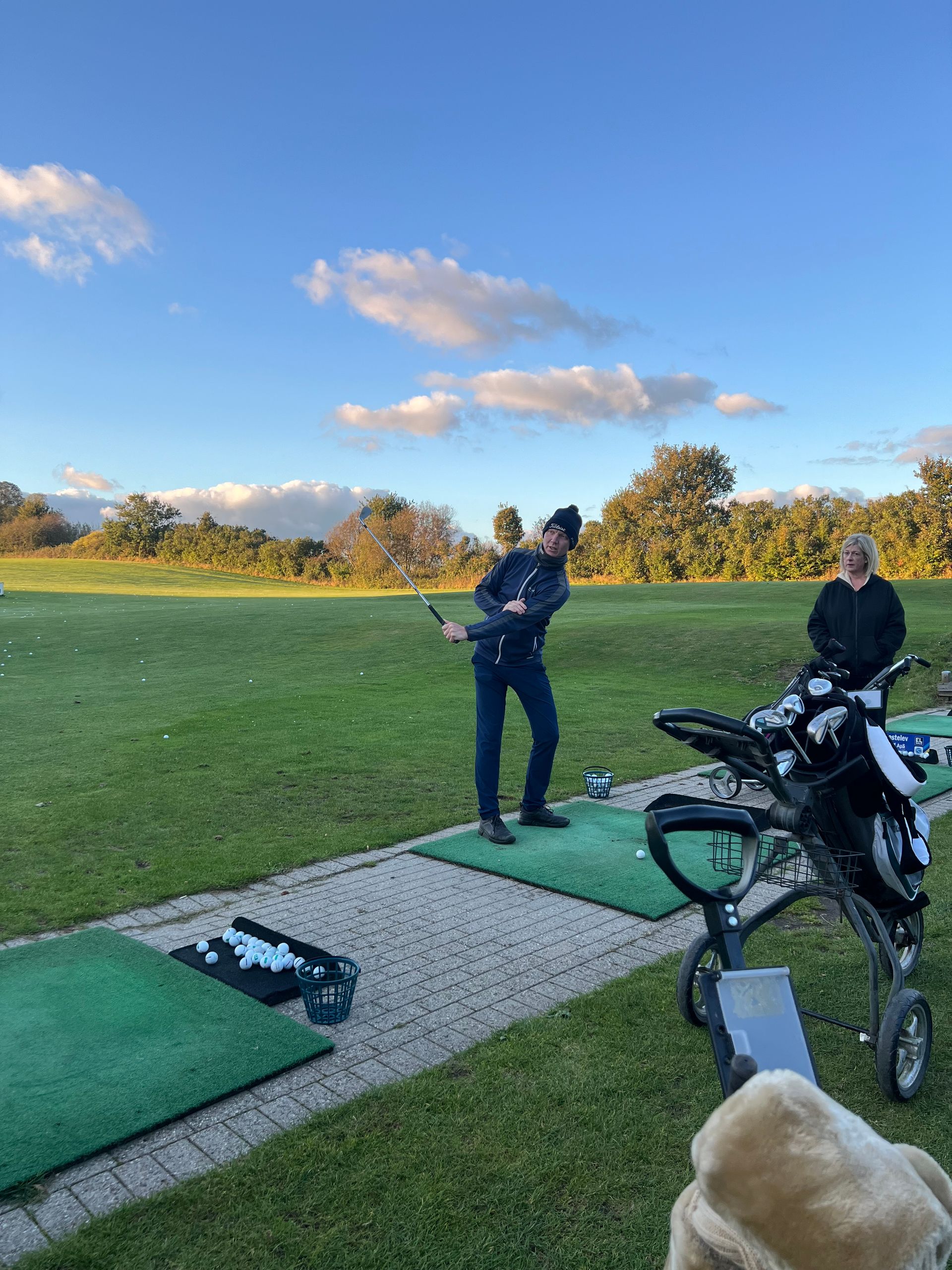 A man is swinging a golf club on a golf course.