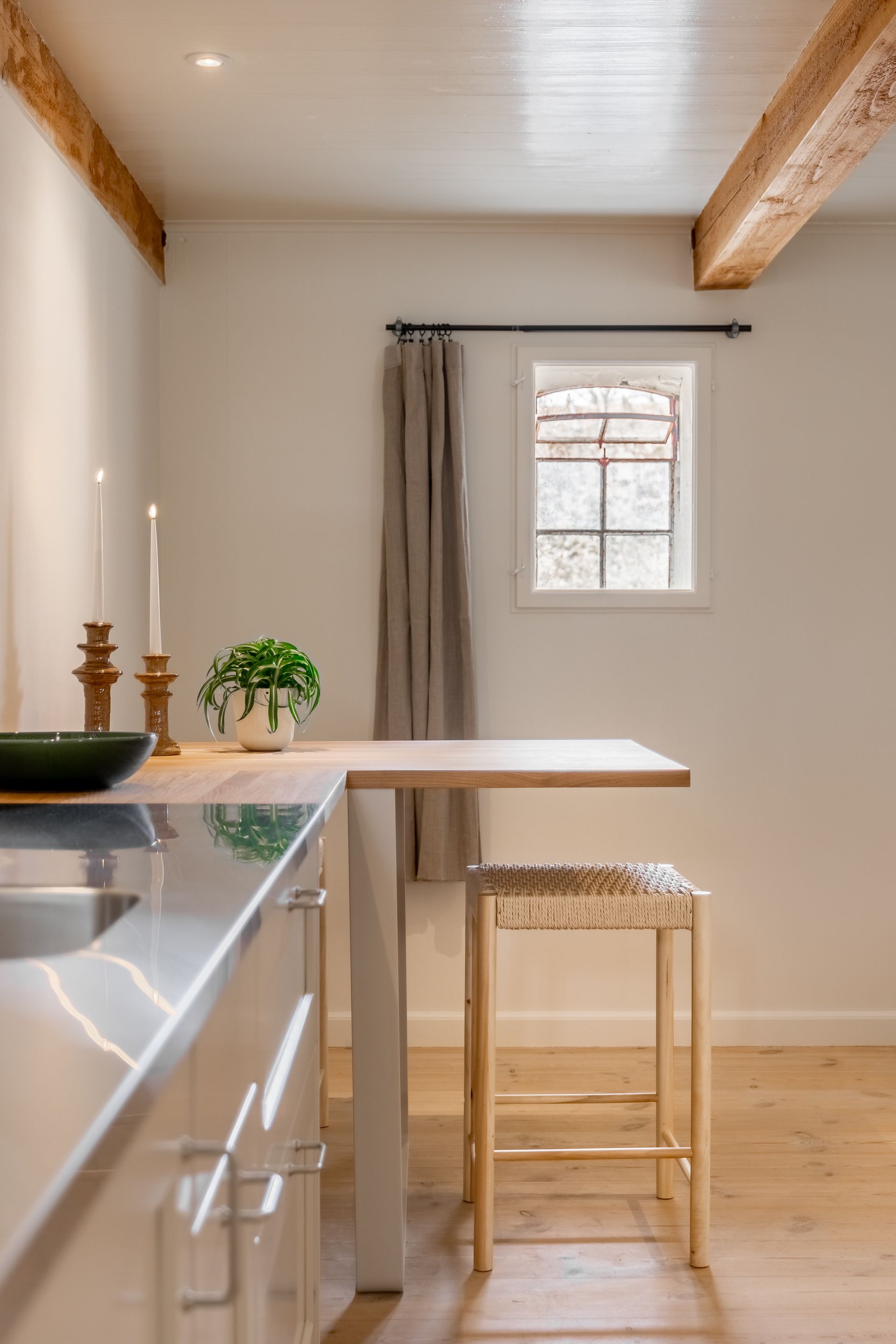 A kitchen with a table and stools and a window.