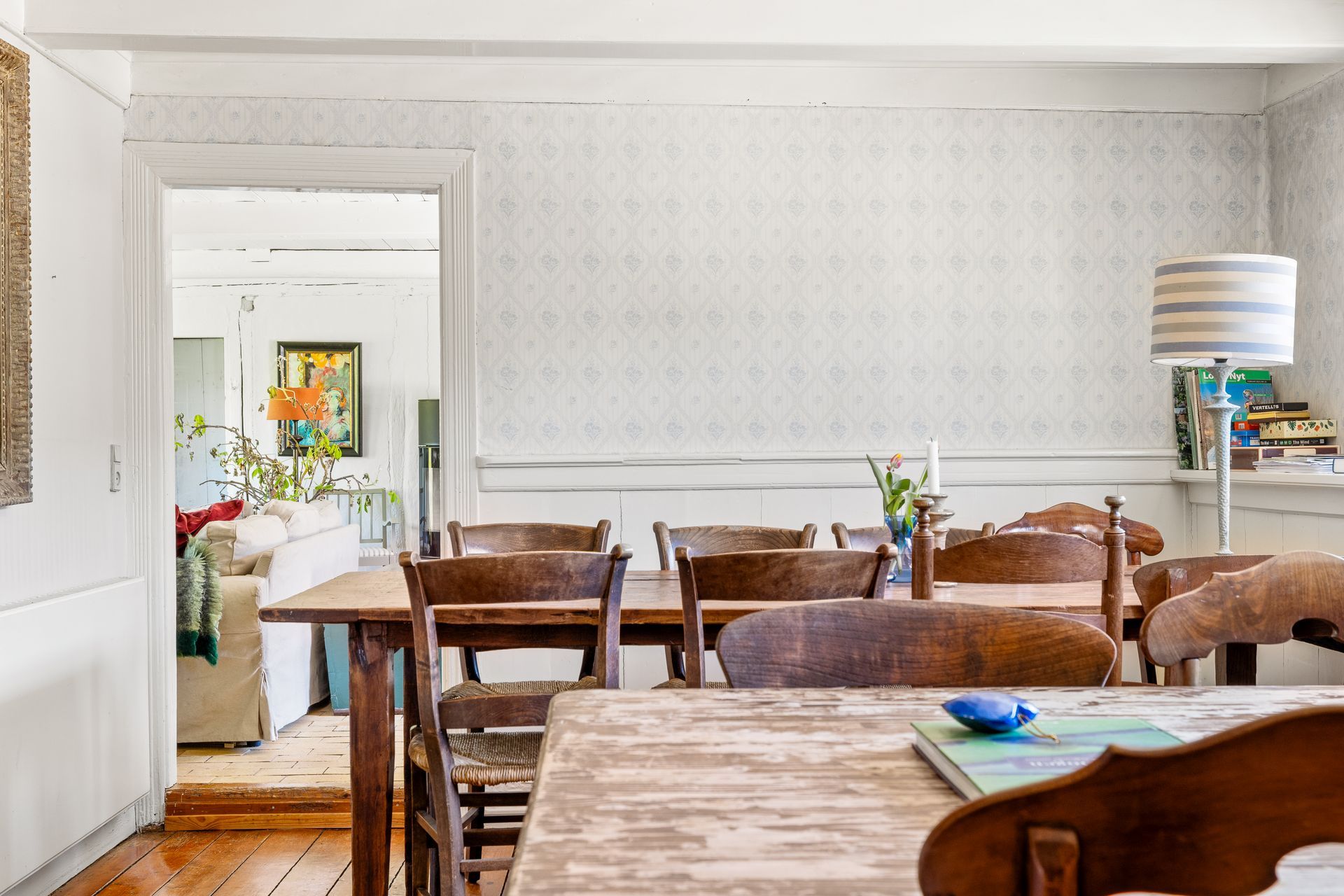 A dining room with a table and chairs and a lamp.