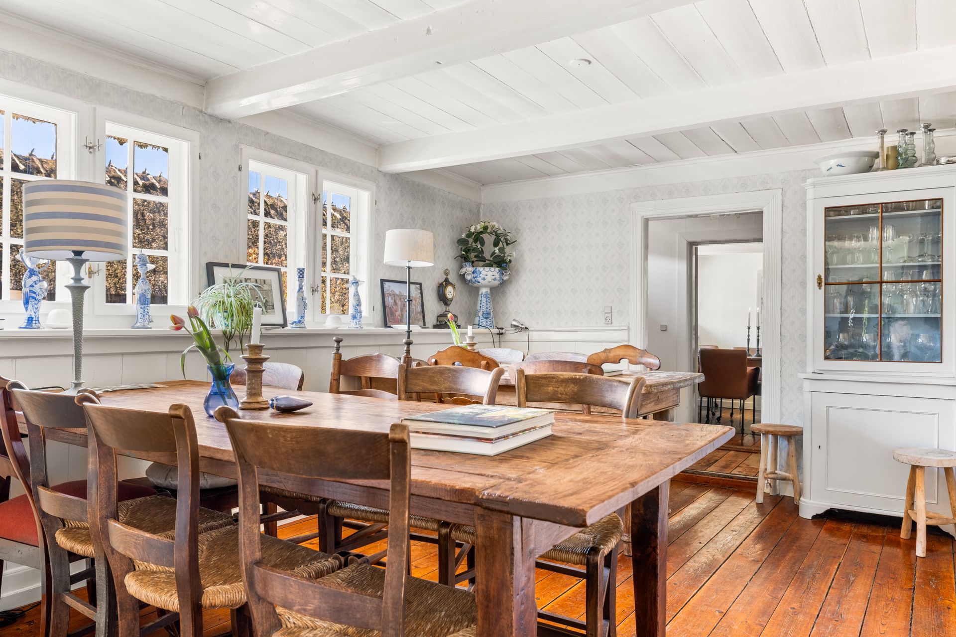 A dining room with a wooden table and chairs.
