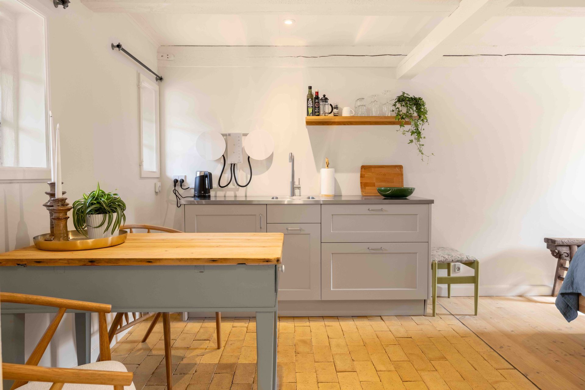 A kitchen with a wooden table and chairs and a wooden floor.