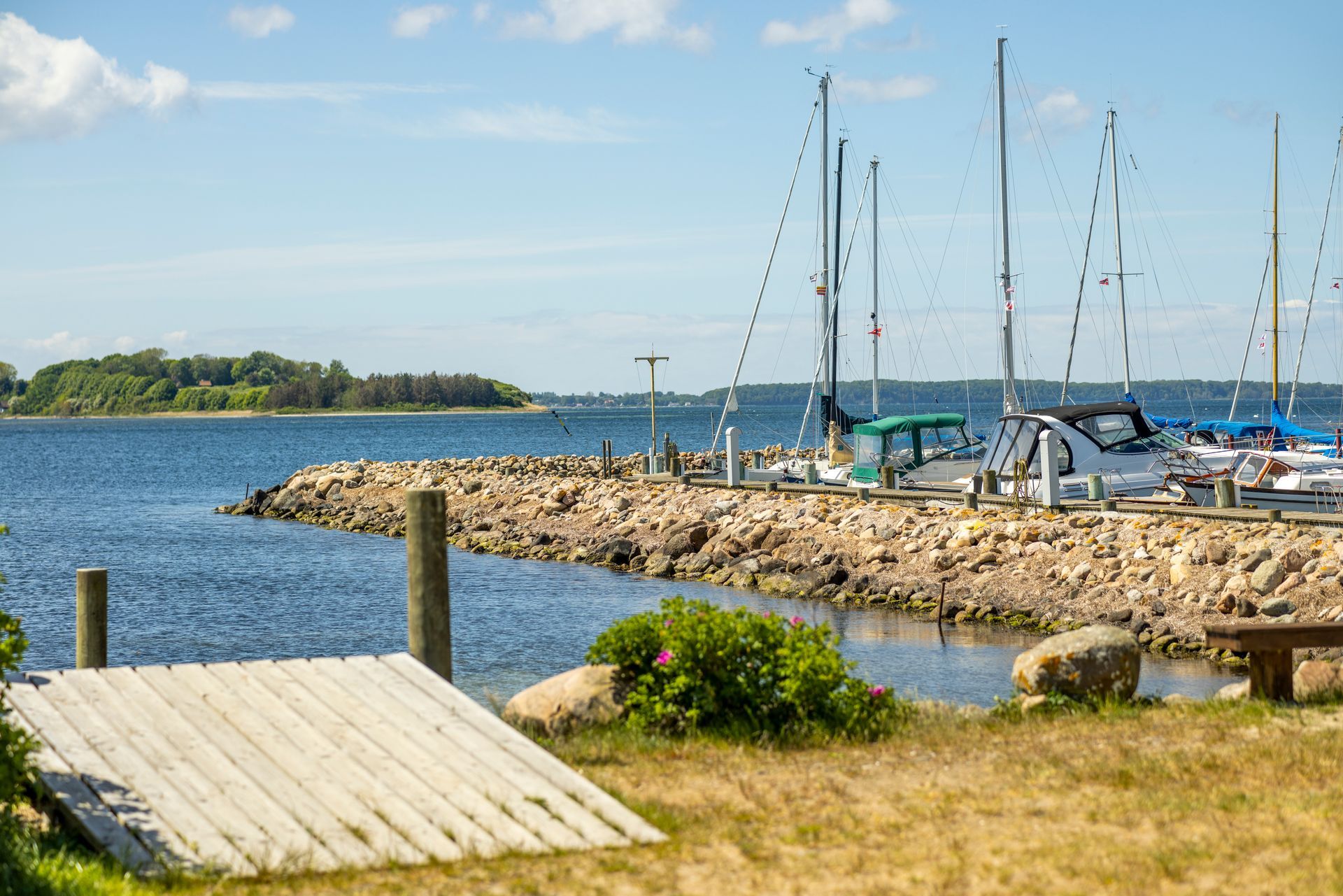 A dock with boats docked at a marina on a sunny day.