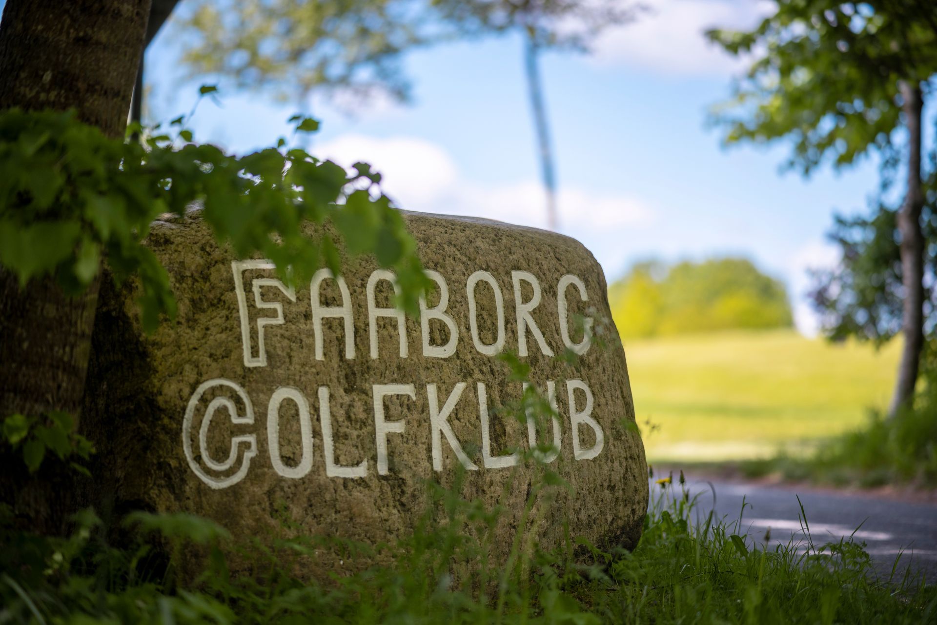 A large rock with the words faaborg golfklub written on it.