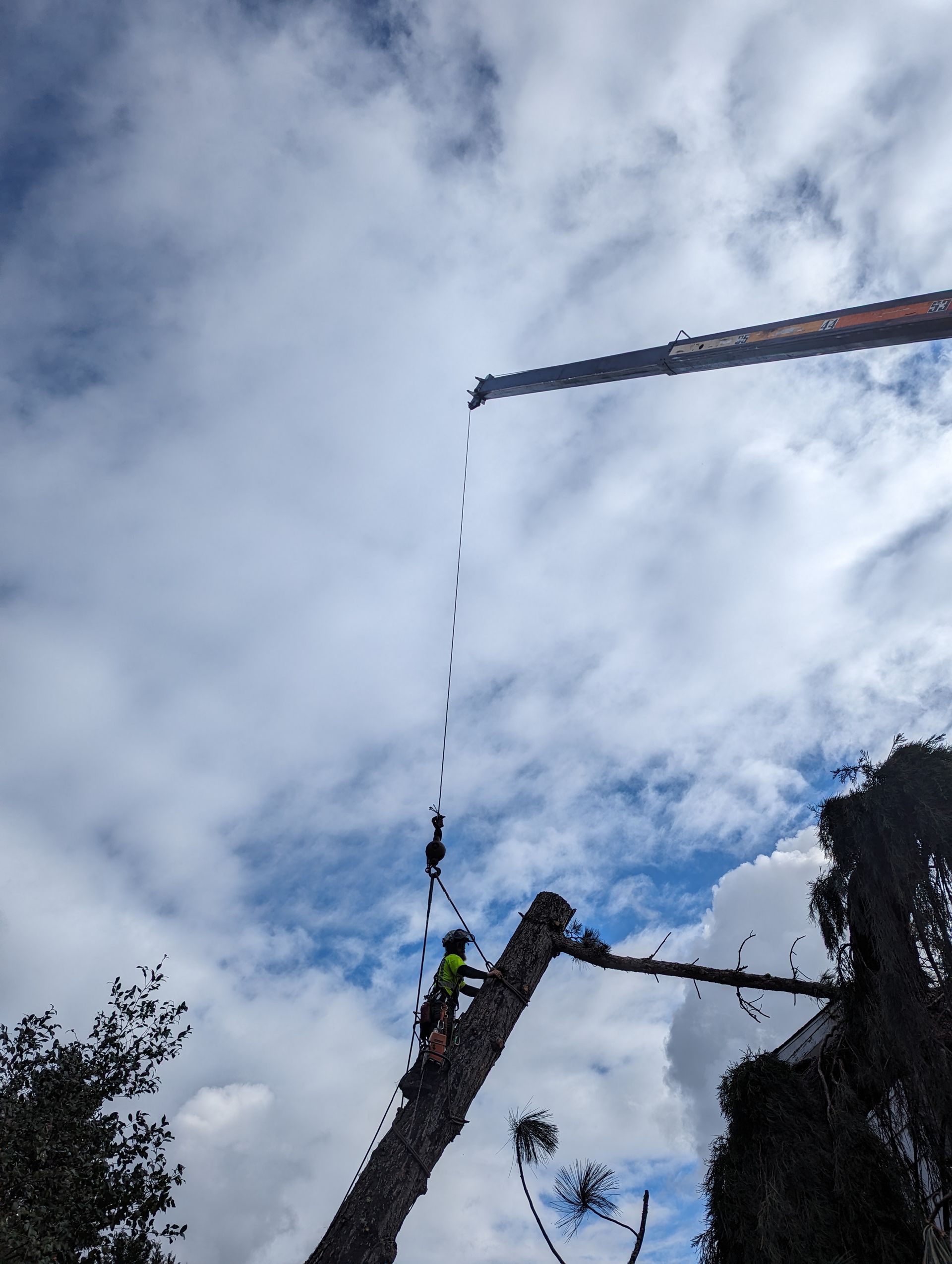 Person bungee jumping between two platforms, suspended by a cord against a cloudy sky.