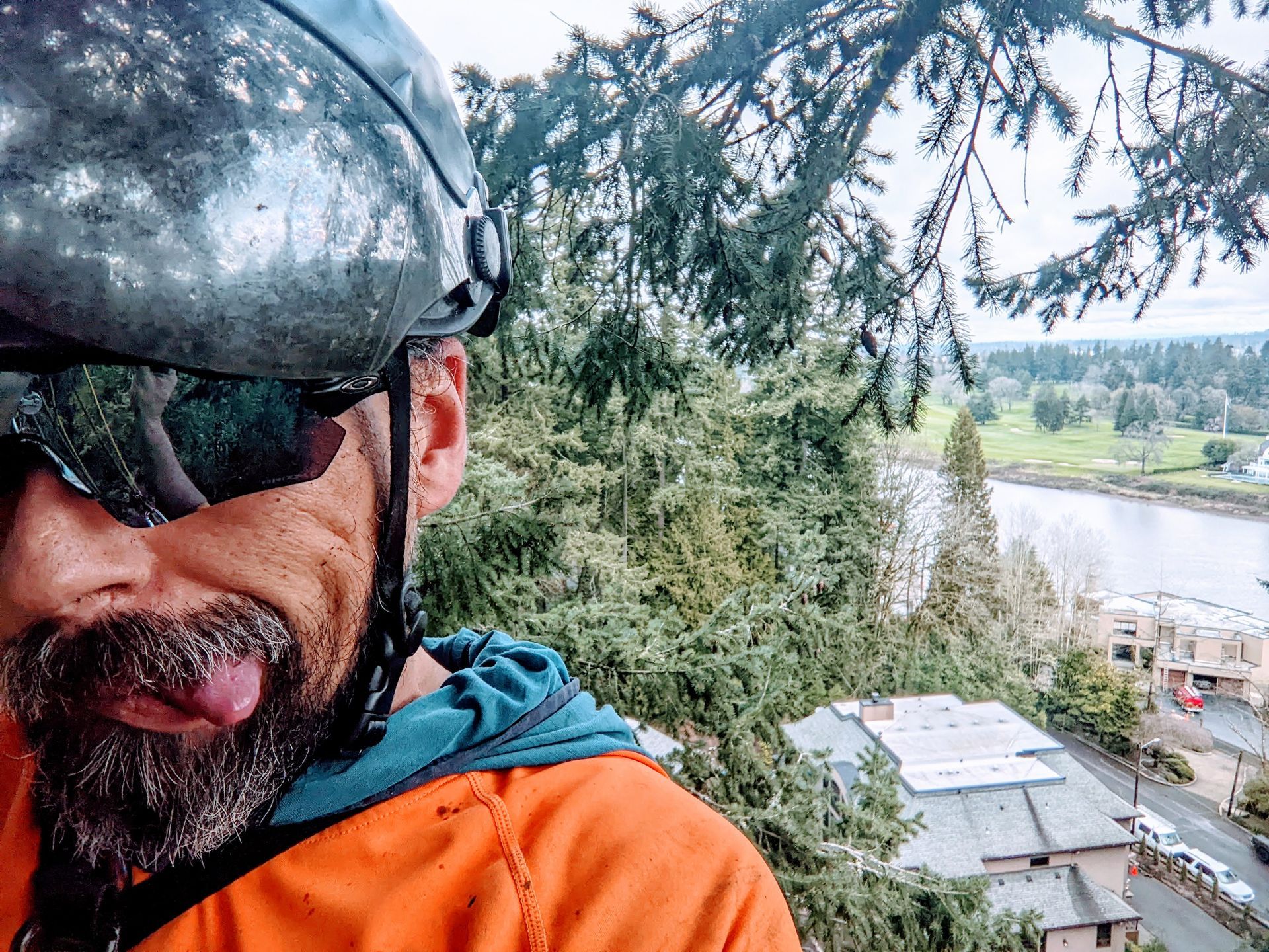 Close-up of a bearded cyclist in sunglasses with a river and trees in the background