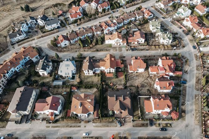 Aerial view of a suburban neighborhood with red-roofed houses and winding streets