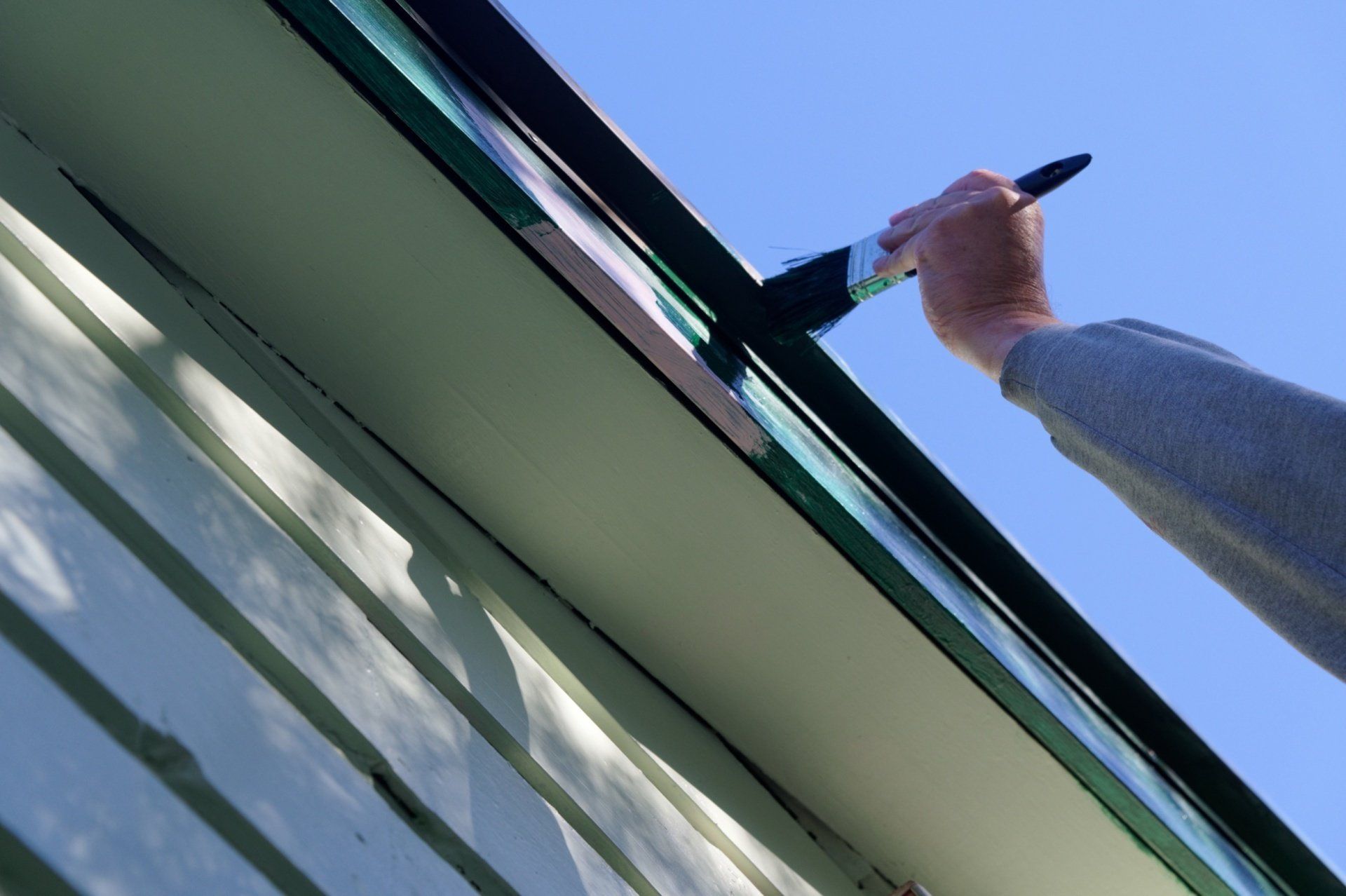 Worker painting house
