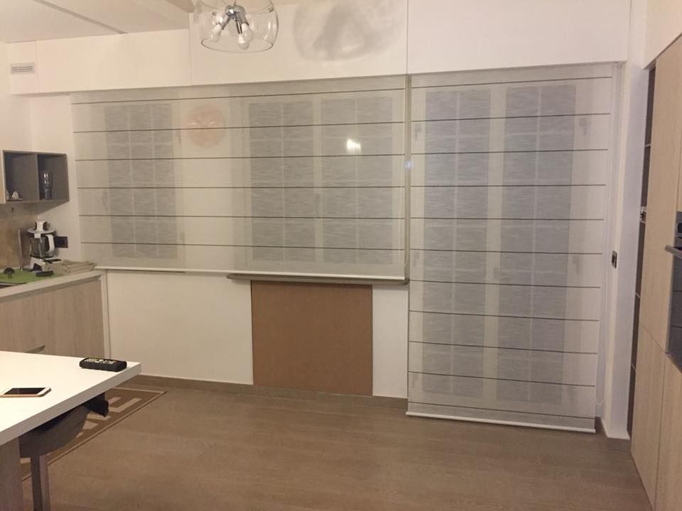 Ufficio vuoto con pannelli a parete in vetro satinato, scrivania e porta bianca sulla destra.