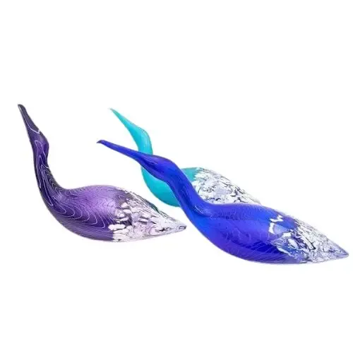 Three colorful glass bird sculptures, purple, blue, and turquoise, with long necks and silver accents.