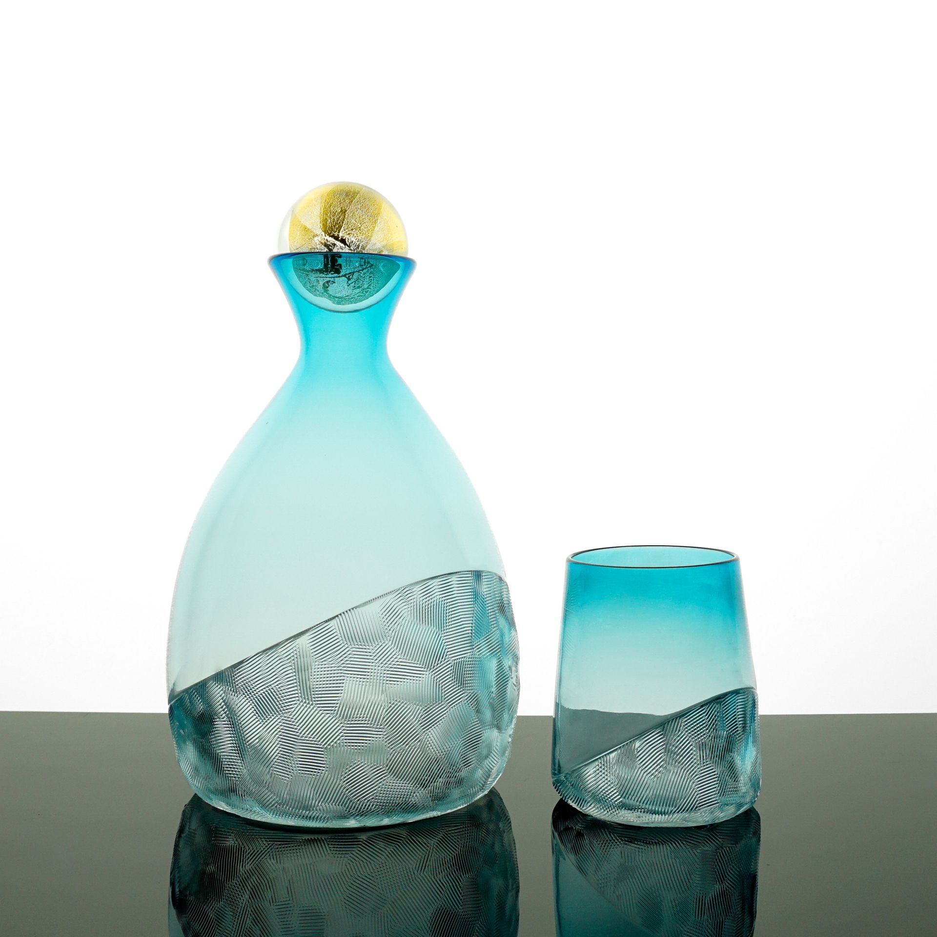 Blue glass decanter and tumbler set; lower half etched, upper half gradient.
