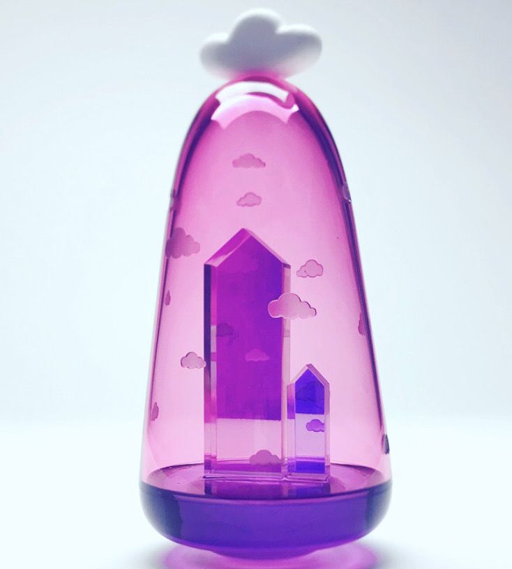 Pink and purple decorative night light with cloud topper, featuring buildings inside.