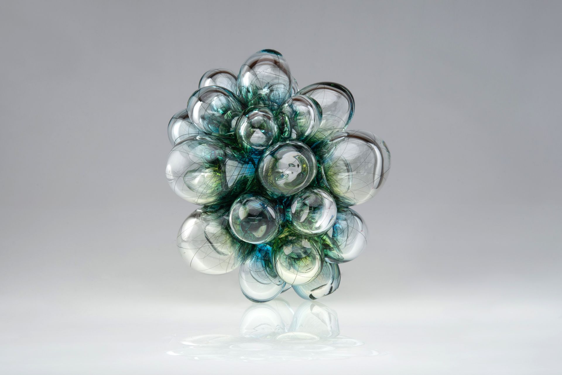 Cluster of transparent glass bubbles with teal and green hues.
