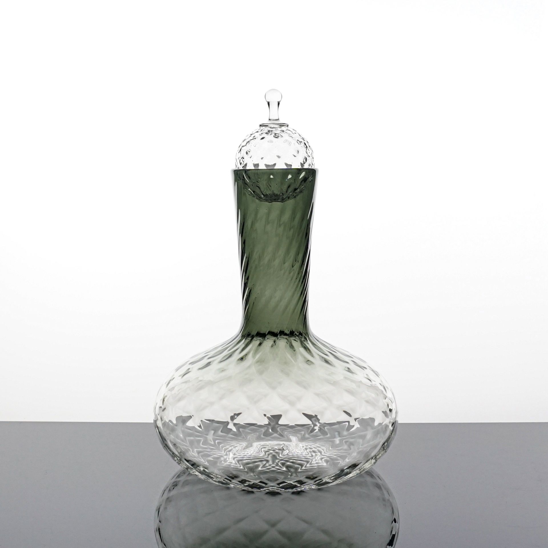 Glass decanter with textured body and neck, clear with green tint, topped with a diamond-cut stopper.