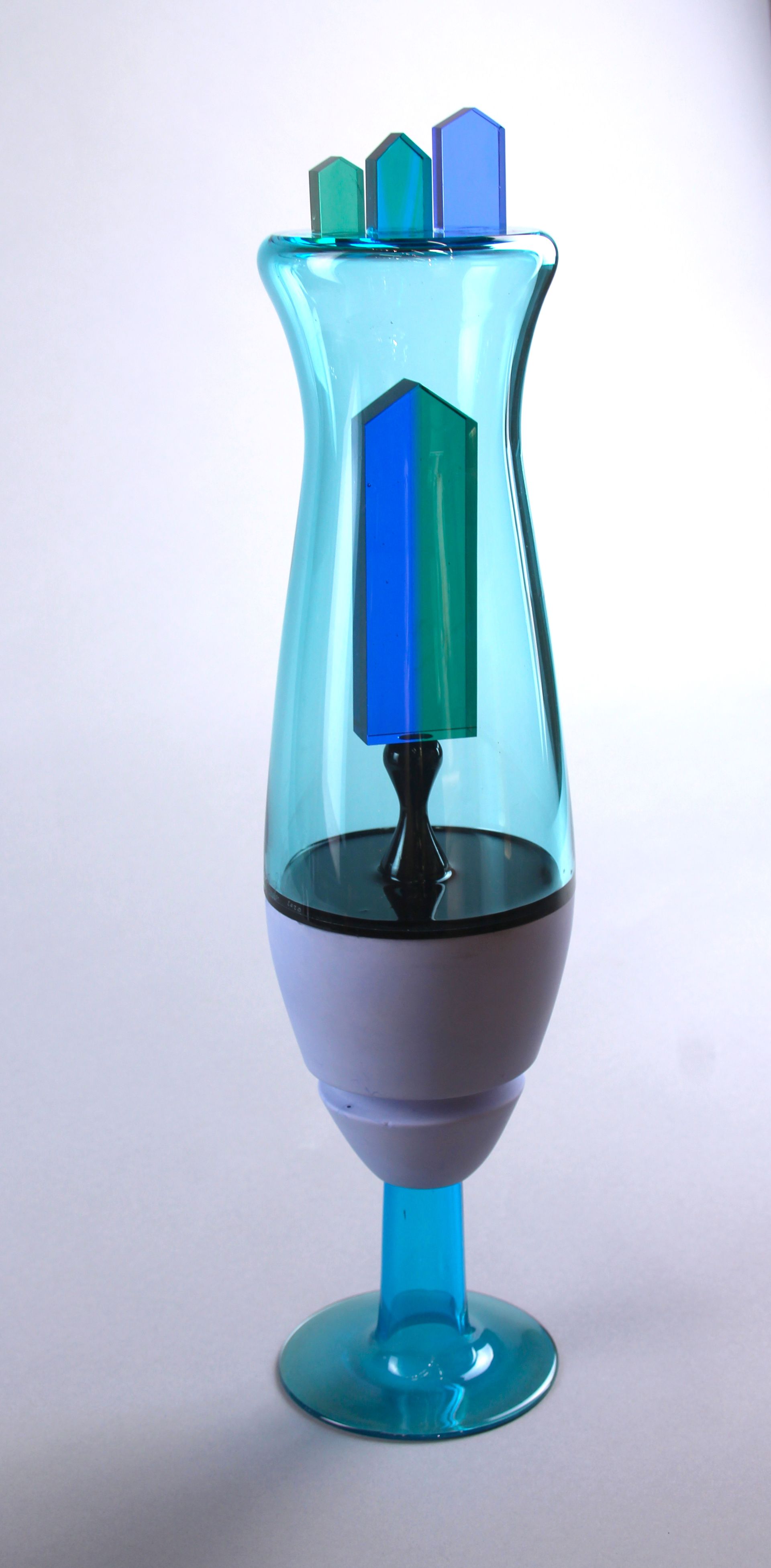 A colorful, stylized lamp with teal, blue, and green accents.