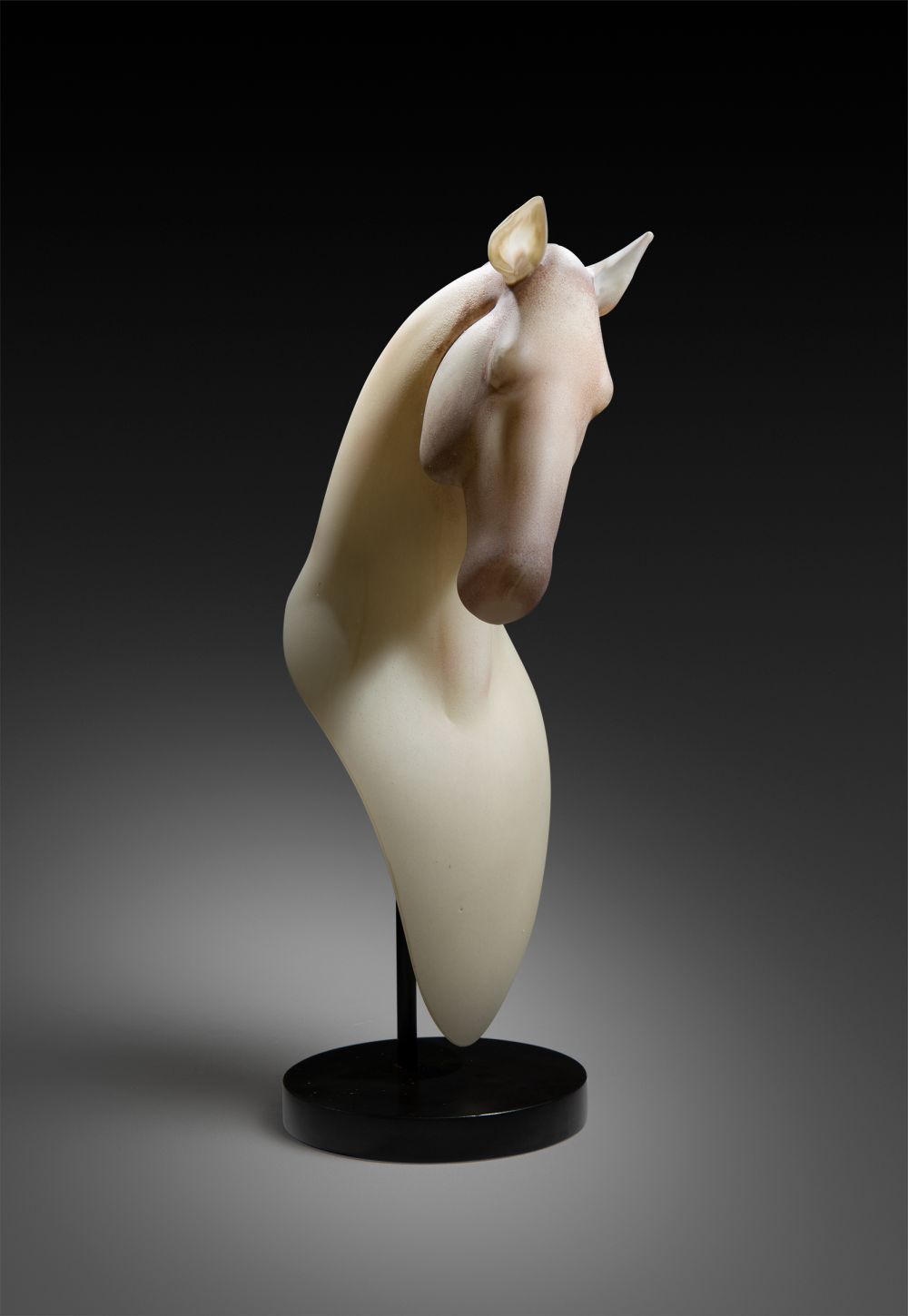 Sculpture of a horse's head and neck in cream-colored alabaster, mounted on a black pedestal.