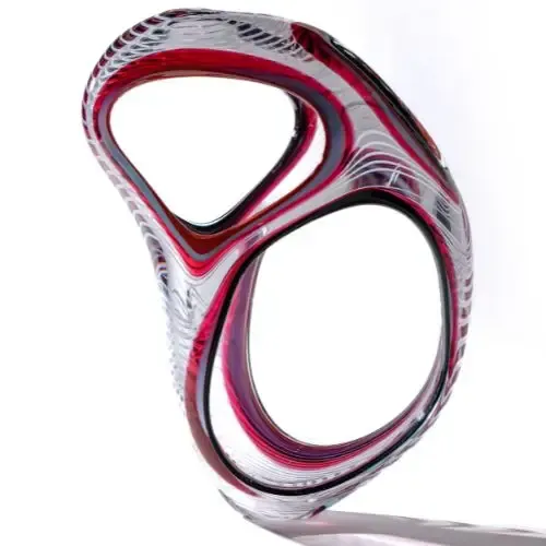 Abstract glass sculpture, red and white, with two open circles, on a white background.