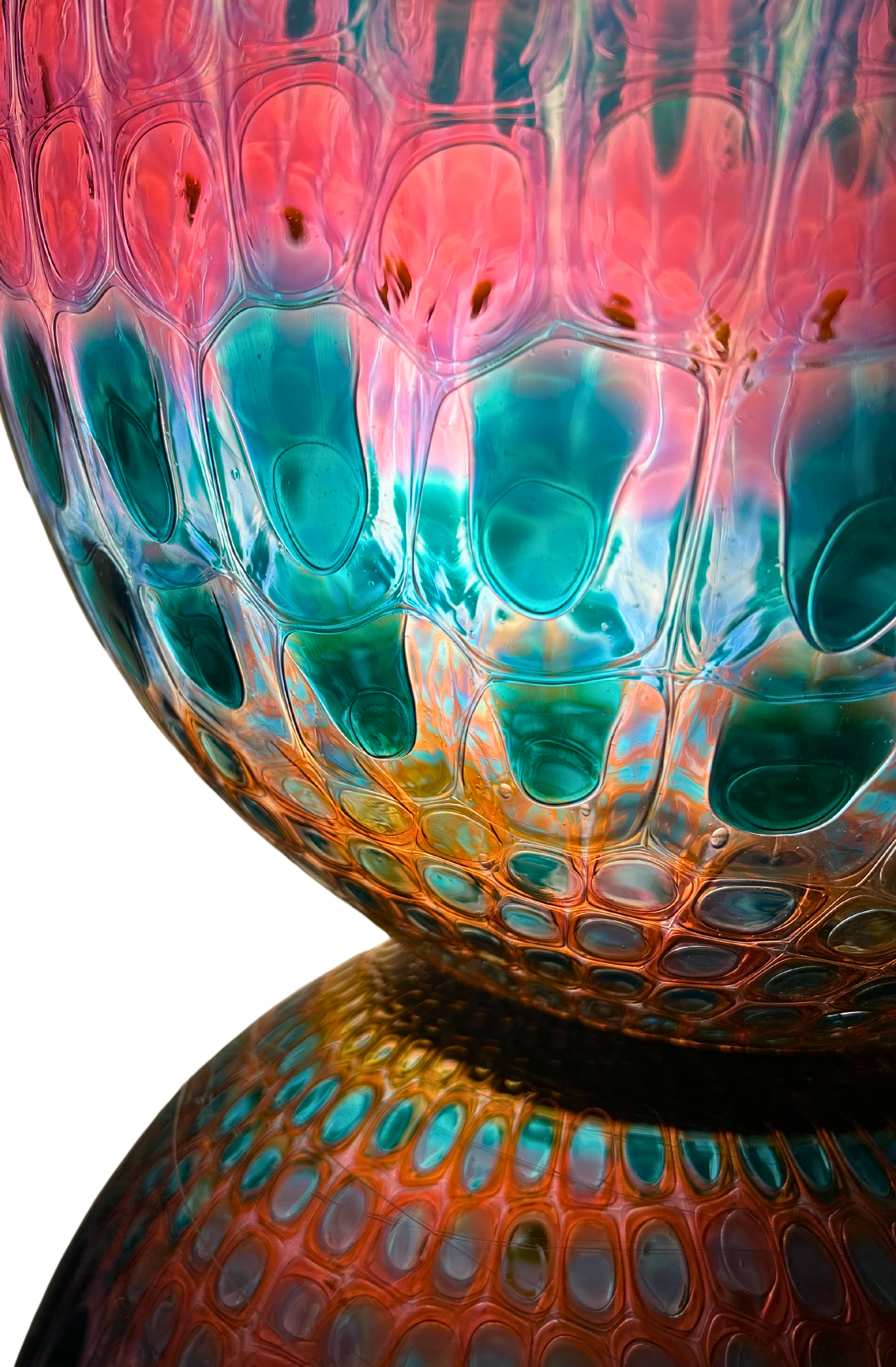 Close-up of a colorful glass sphere with a textured, cellular pattern. Vibrant pink, teal, and orange hues.