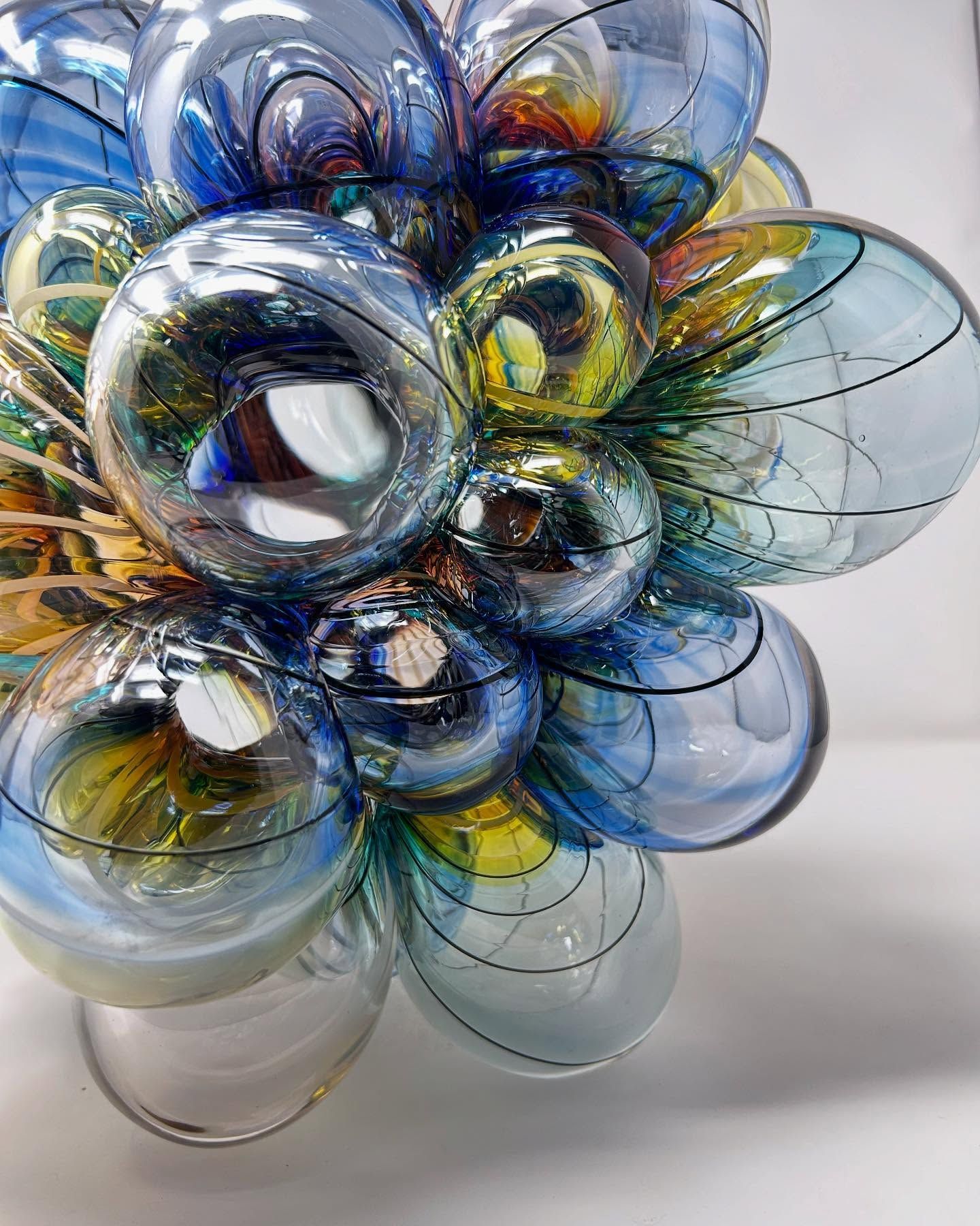A cluster of blue and gold glass spheres, reflecting light and creating an abstract, bubbly form.