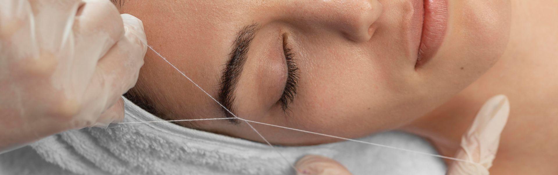 Une femme se fait épiler les sourcils dans un salon de beauté.