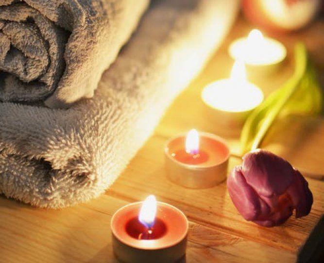 Il y a des bougies et une fleur sur la table.
