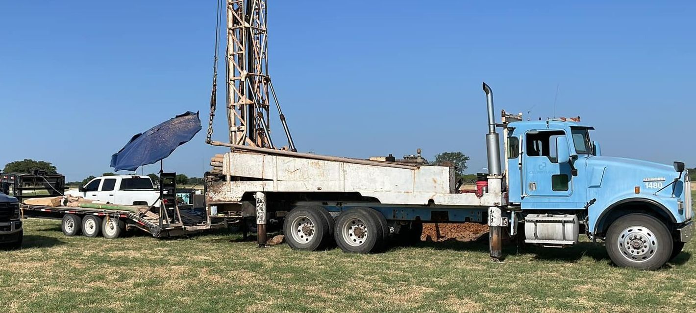 A blue truck with a drilling rig attached to it is parked in a field — Seminole, TX — Shpuetz Drilling A blue truck with a drilling rig attached to it is parked in a field — Seminole, TX — Shpuetz Drilling