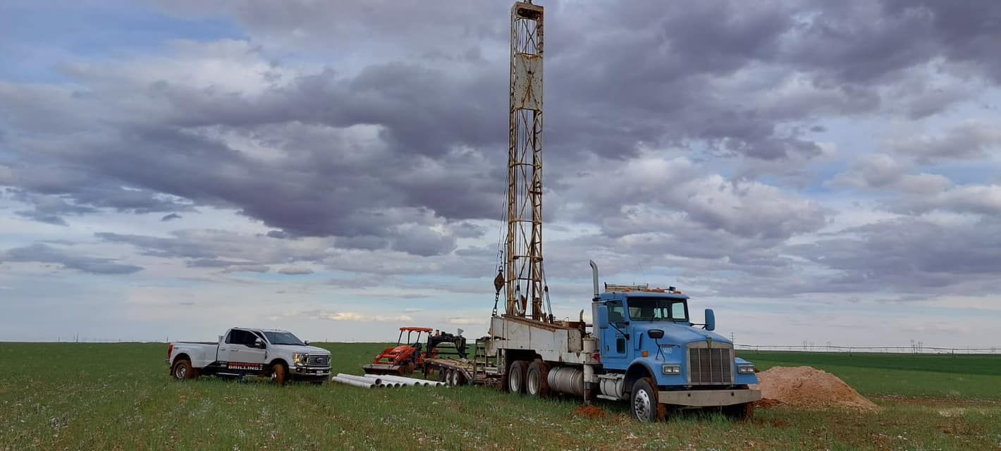 A water well is being drilled at night with a full moon in the background — Seminole, TX — Shpuetz Drilling
