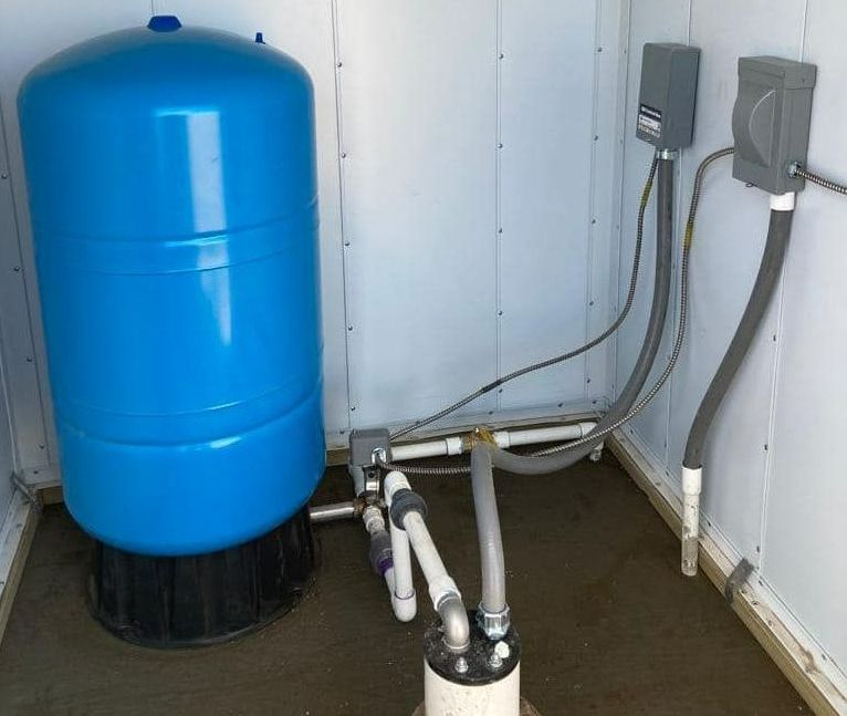 A blue water tank is sitting in a room next to pipes — Seminole, TX — Shpuetz Drilling A blue water tank is sitting in a room next to pipes — Seminole, TX — Shpuetz Drilling