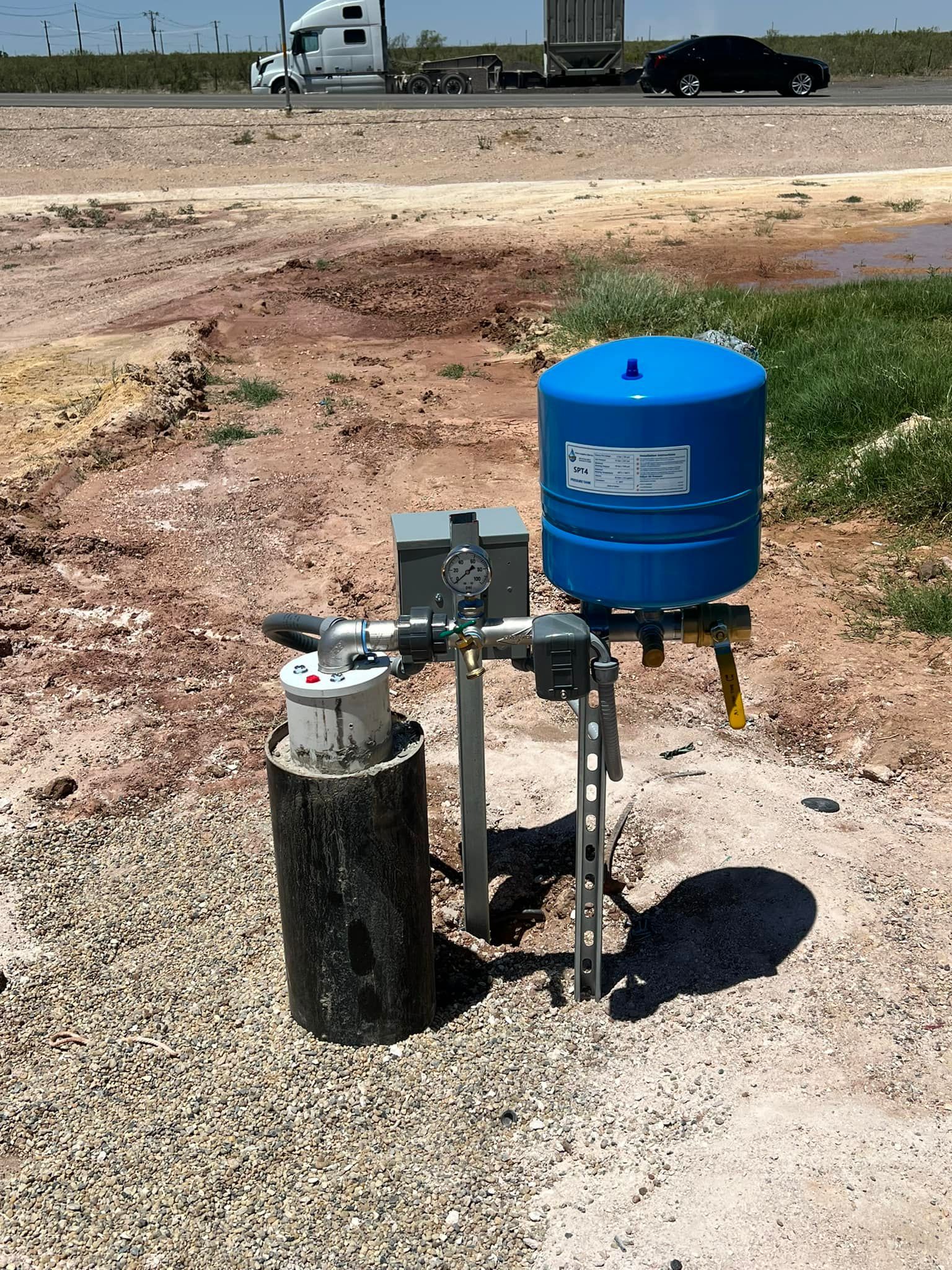 A blue water tank is sitting on top of a concrete pole in a dirt field — Seminole, TX — Shpuetz Drilling