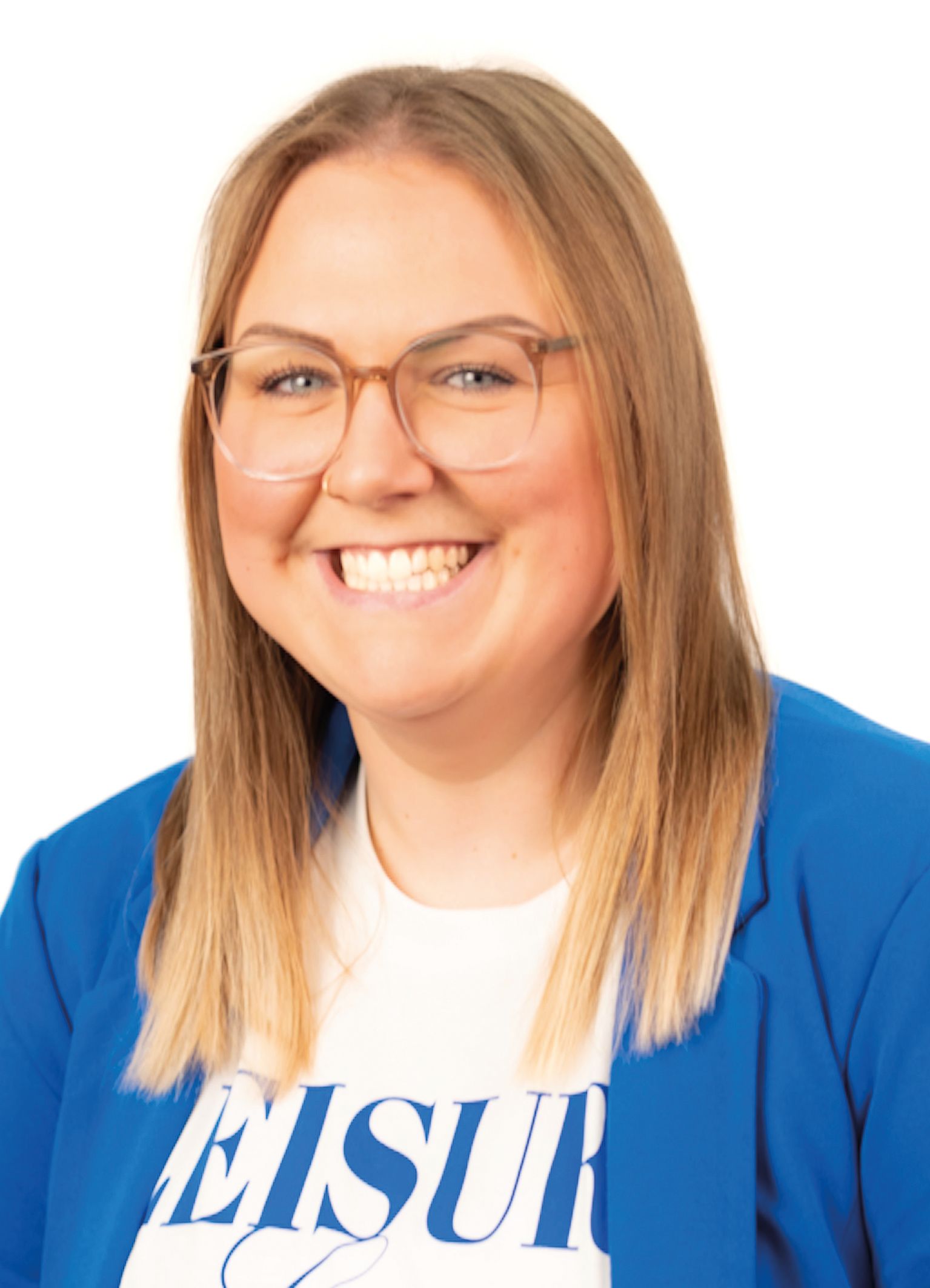 Eine Frau mit Brille lächelt in die Kamera; sie trägt einen blauen Blazer und ein weißes T-Shirt.