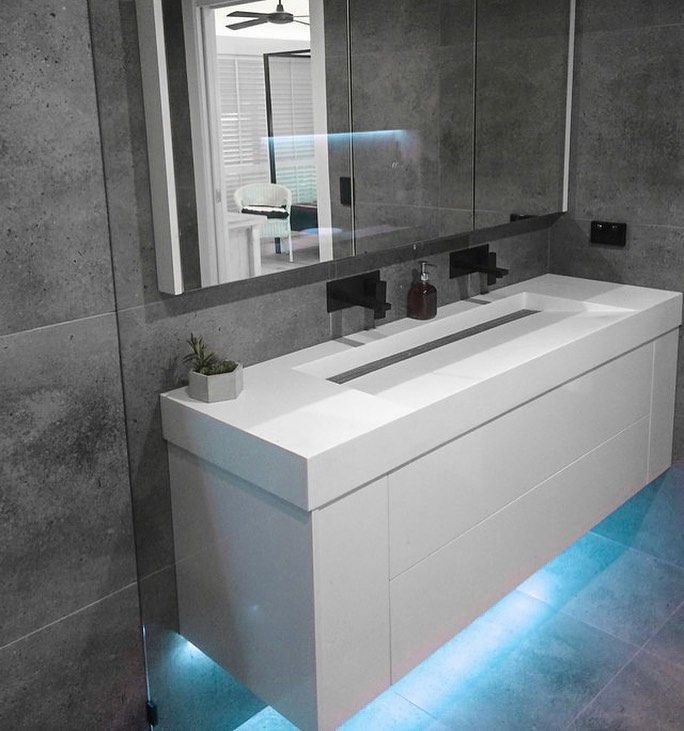 A bathroom with a large sink and a mirror