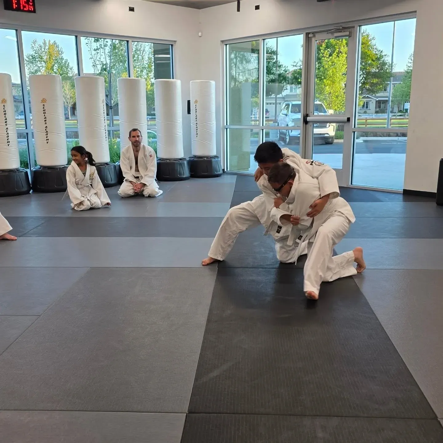 Martial arts courses in Brentwood, CA with two students practicing grappling on mats.