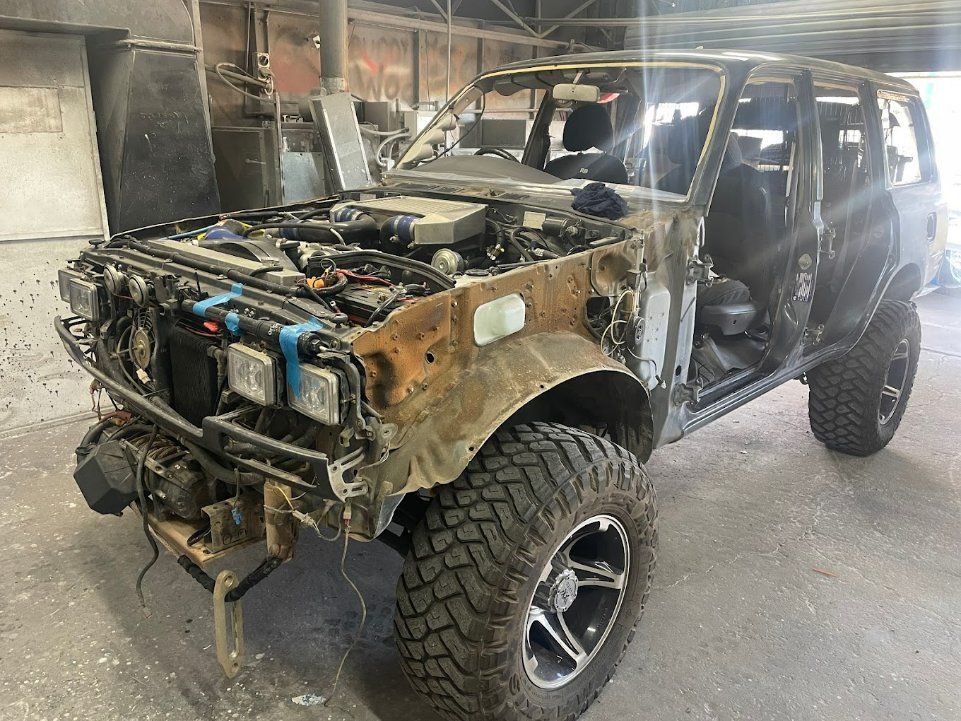 A Jeep with The Hood up Is Sitting in A Garage — East Maitland Body Repairs in Maitland, NSW