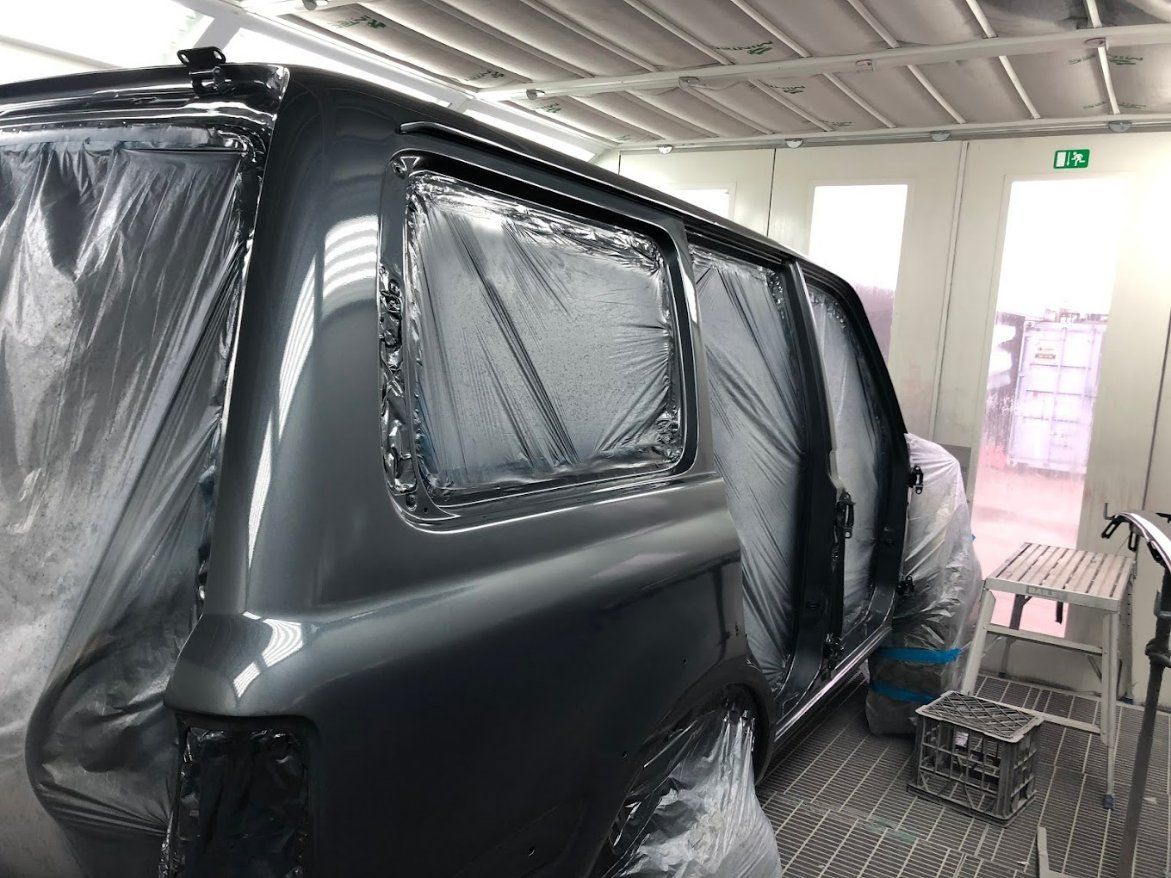 A Car Is Being Painted in A Paint Booth — East Maitland Body Repairs in East Maitland, NSW