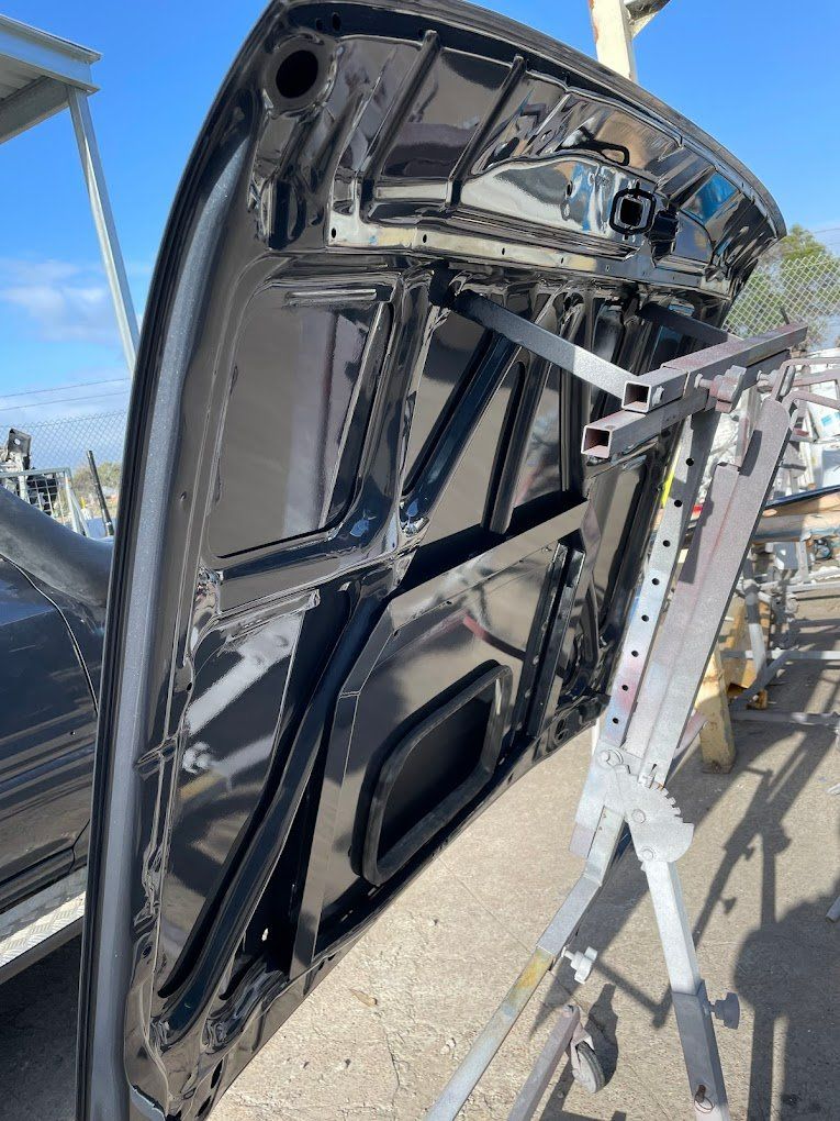 The Hood of A Car Is Sitting on A Stand — East Maitland Body Repairs in East Maitland, NSW