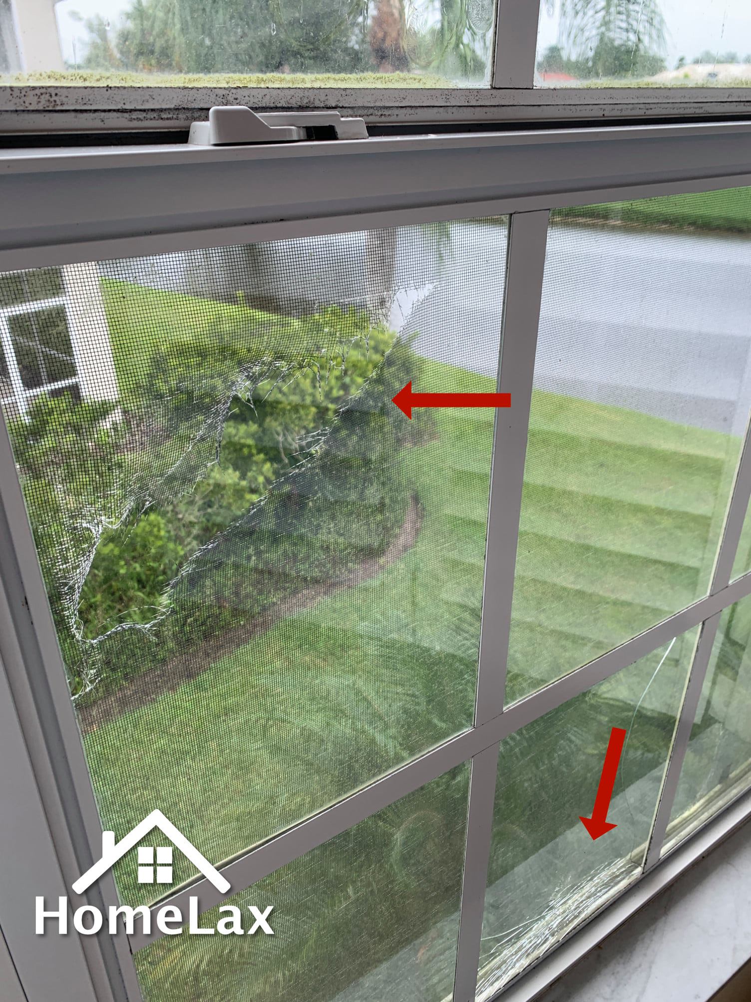 A white window frame with a screen, showing two red arrows pointing to damaged, frayed screen mesh and debris.