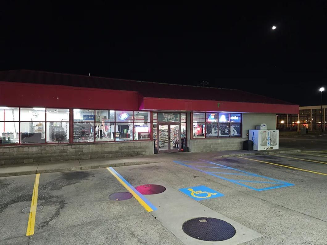 A red building with a handicapped parking spot in front of it at night.