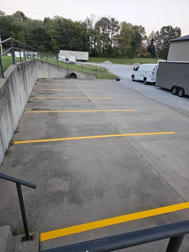 A parking lot with yellow lines and stairs leading up to it.