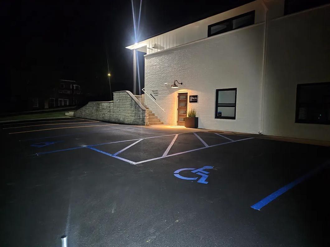 A handicapped parking spot in front of a building at night.