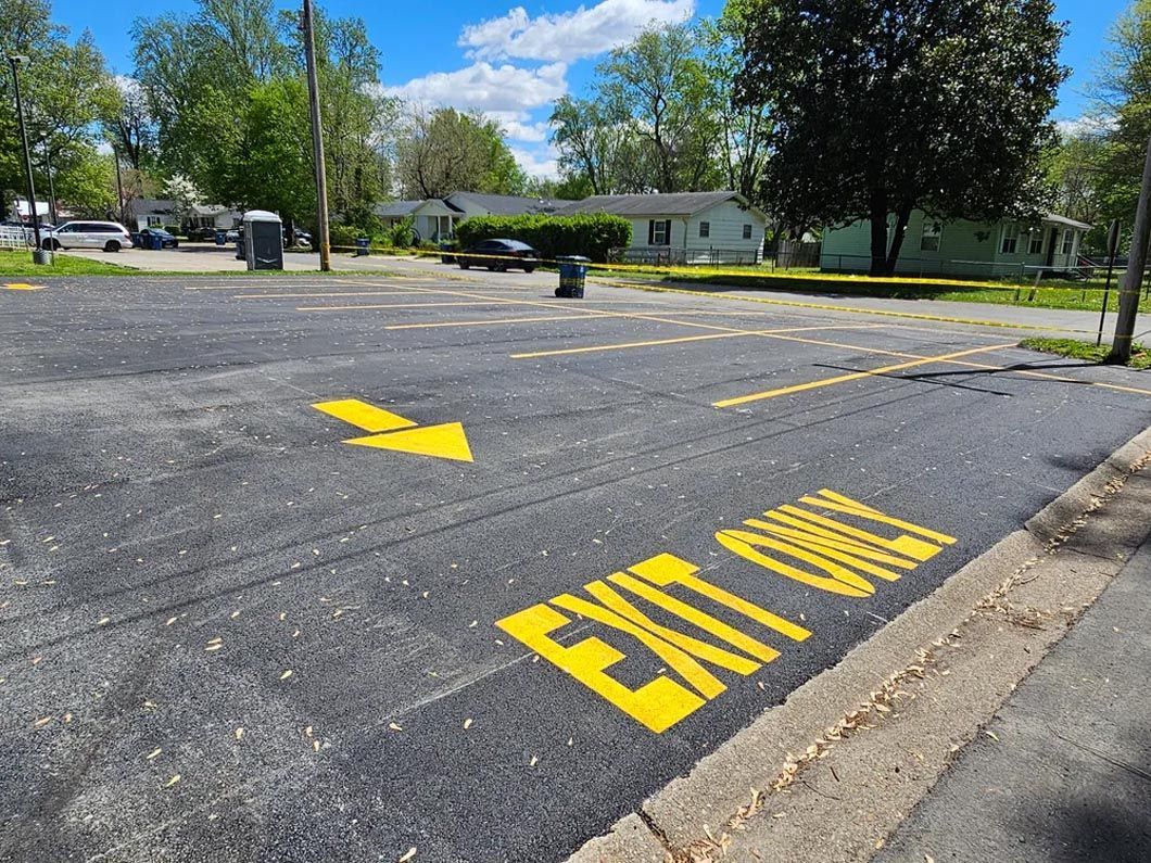 A parking lot with a yellow exit only sign painted on it.