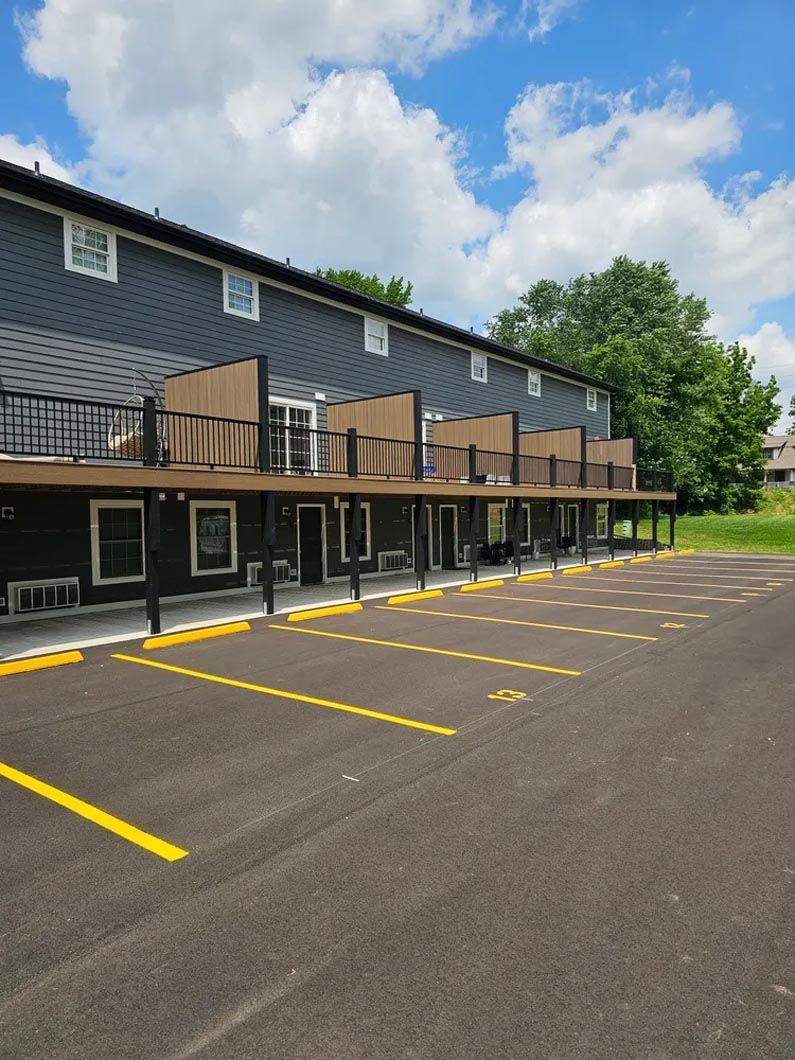 A row of apartment buildings with a parking lot in front of them