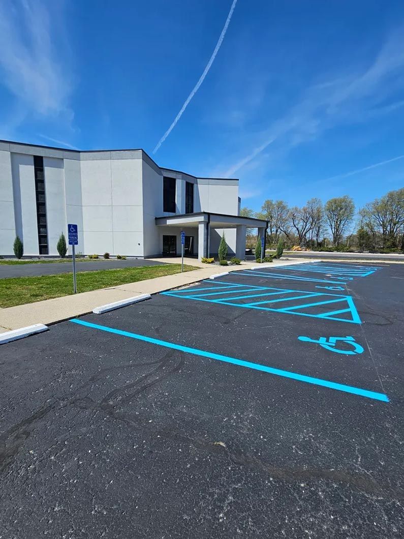 A parking lot with a handicapped parking space in front of a building.