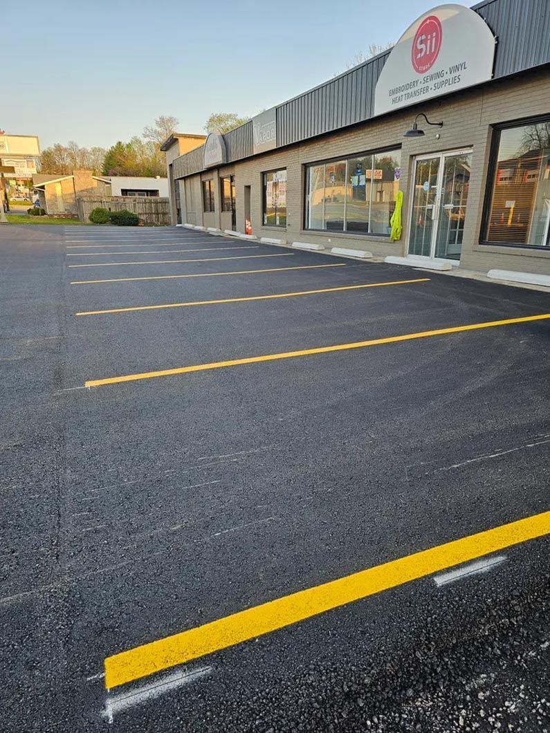A parking lot with yellow lines in front of a building.