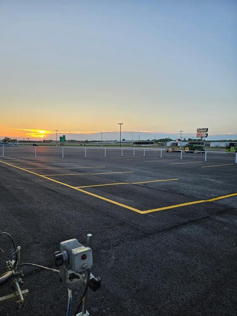A helicopter is parked in a parking lot at sunset.