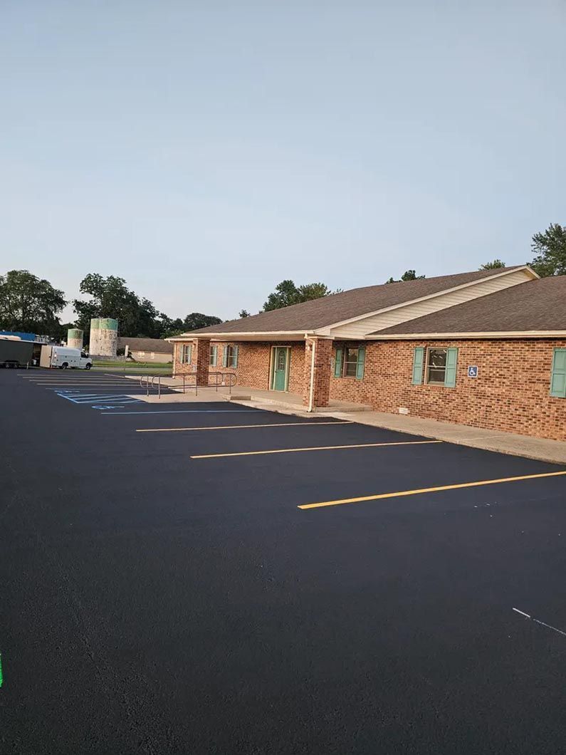 A brick building with a parking lot in front of it.