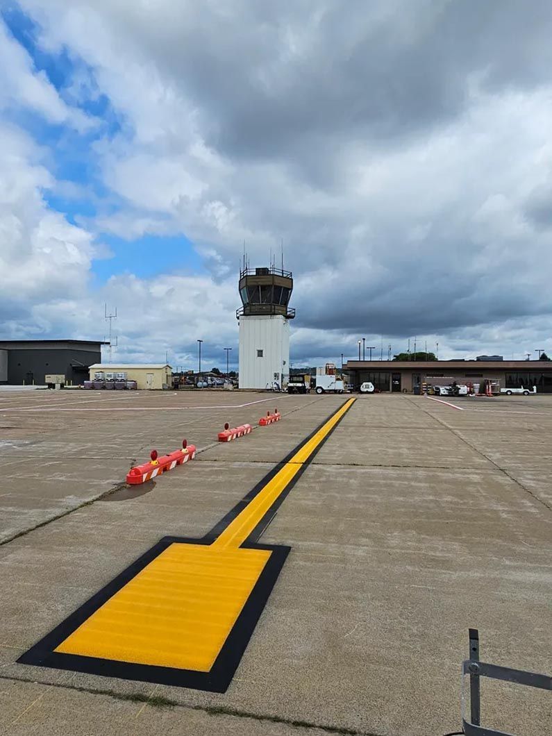 A yellow arrow is painted on the ground at an airport