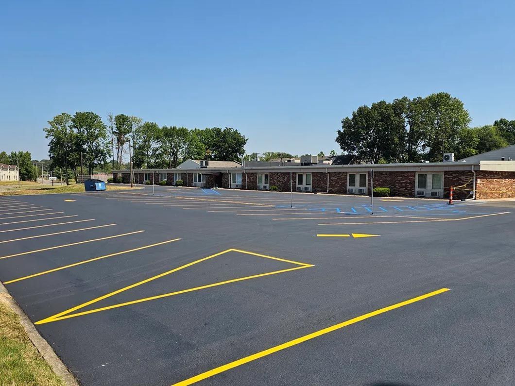 A parking lot with yellow lines in front of a motel.