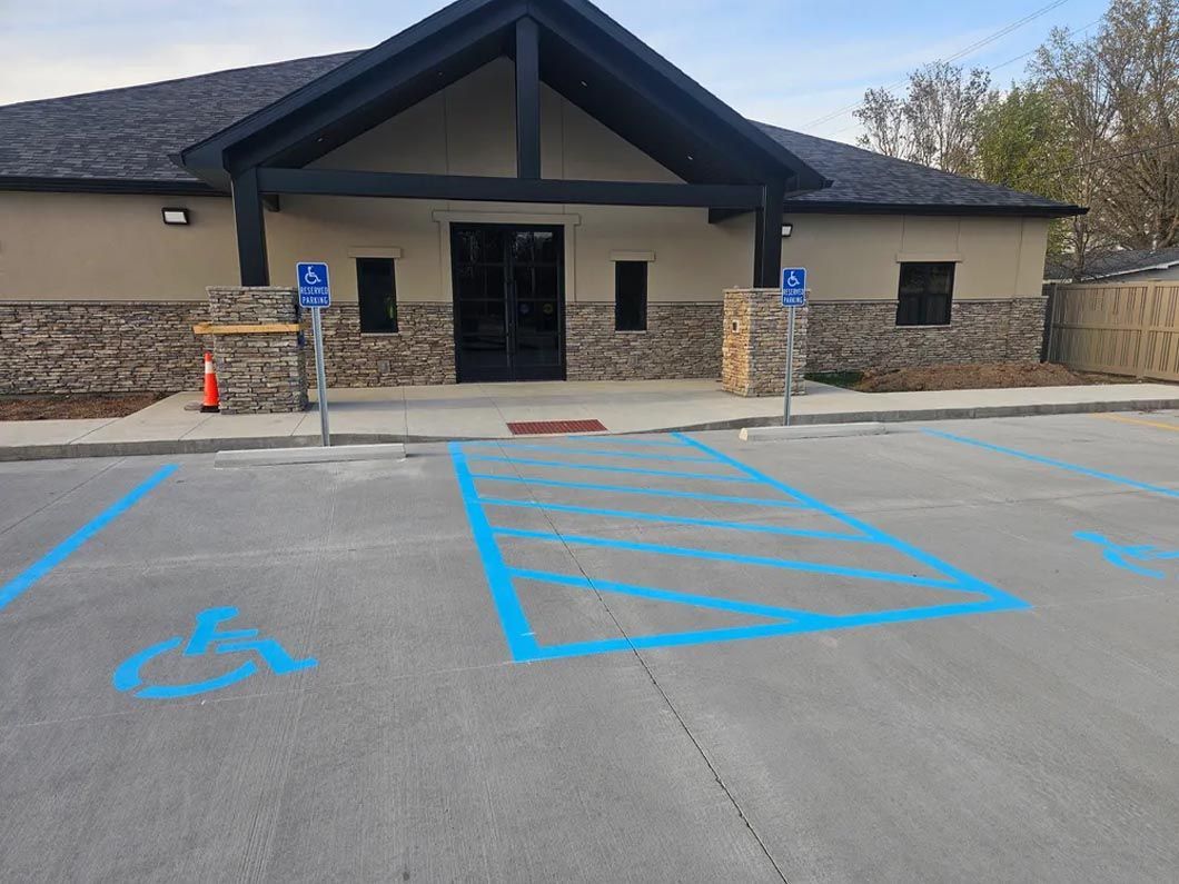 A handicapped parking spot is painted blue in front of a building.