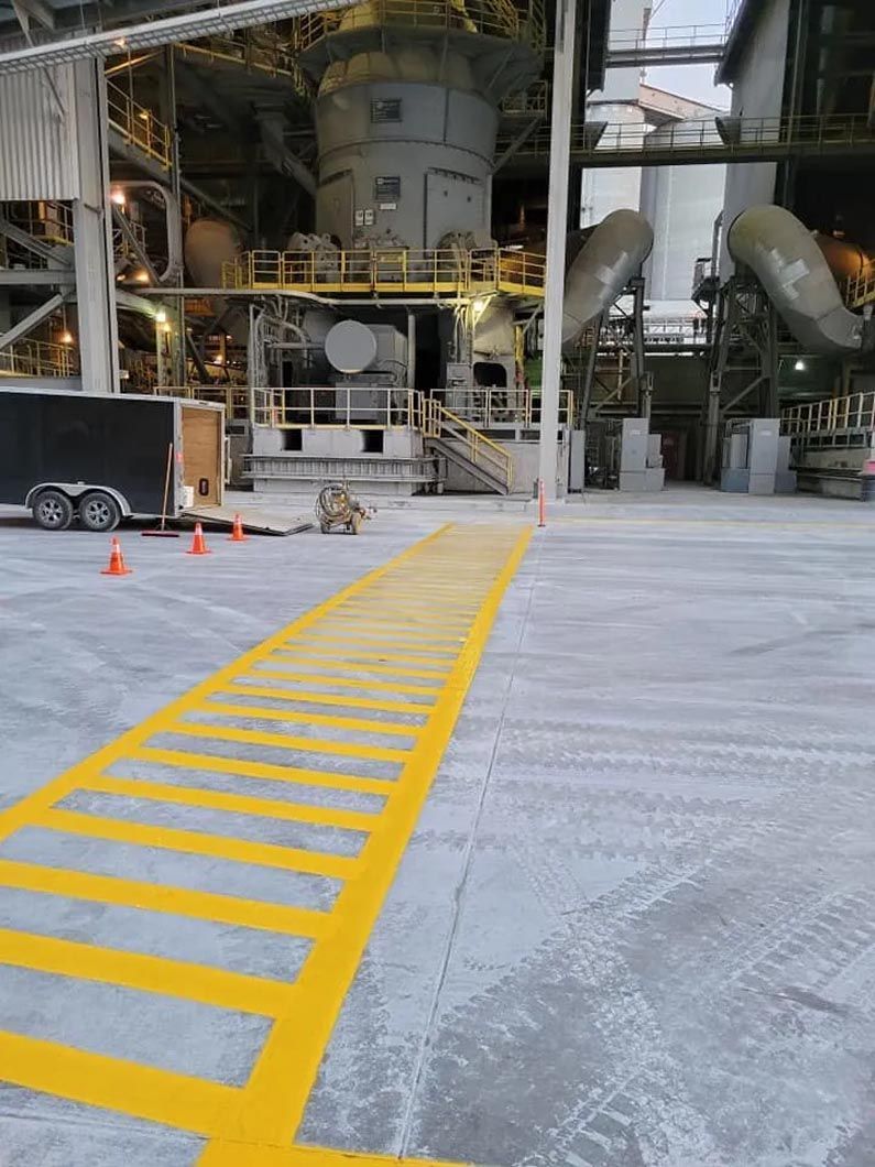 A yellow line is painted on the ground in front of a factory