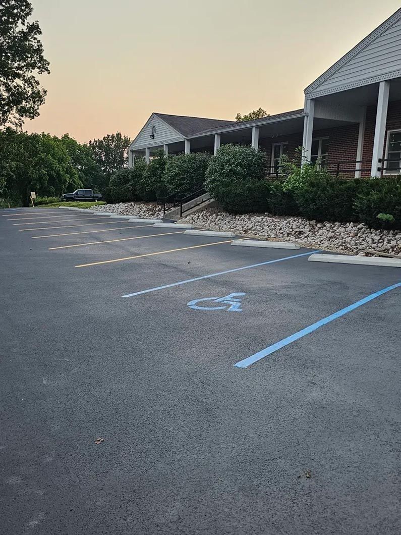A parking lot with a handicapped parking spot in front of a building.
